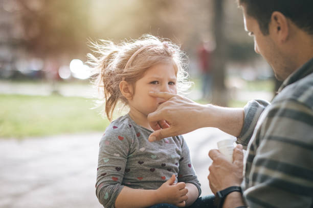 istock Young father applying suntan lotion on daughter's face 1313001389