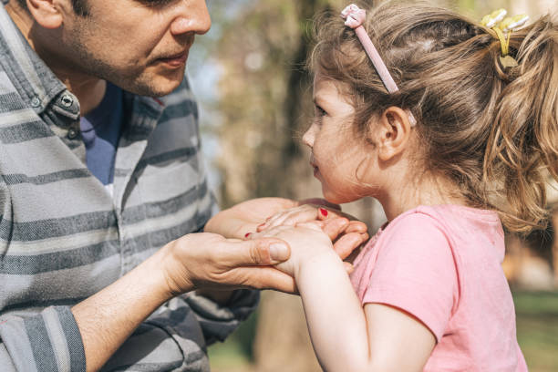 istock Young father painting daughter's finger nails 1313001460