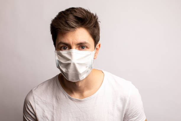 istock a man in a medical mask. Protection from coronavirus. white background 1313001495