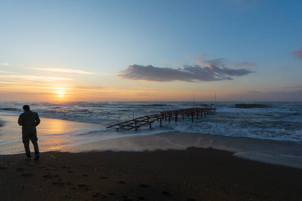 istock A man by the sea during the sunrise 1313003163