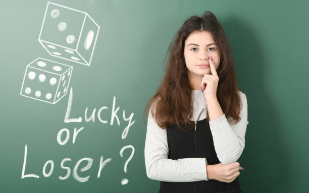 istock Pre-adolescent girl ponders her next step. Dice drawn in chalk 1313007915