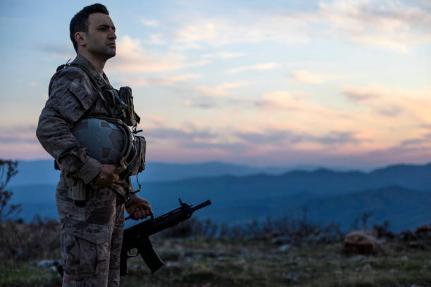 istock Army Soldier standing against sunset sky in battlafield 1313007965