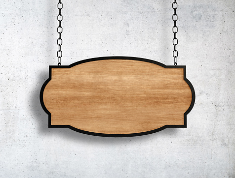 Wooden sign hanging on chains and concrete wall background