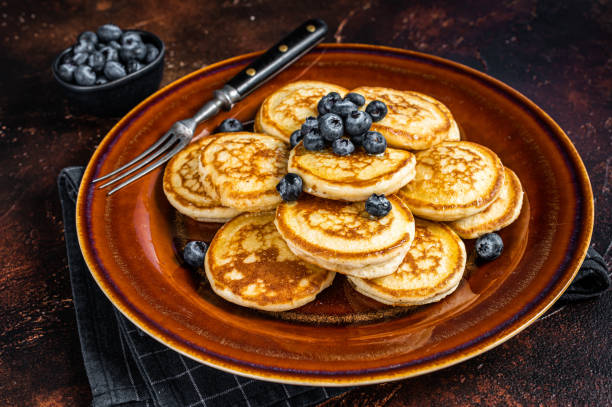 istock Plate with pancakes with fresh blueberries and syrup . Dark background. Top View 1313011741