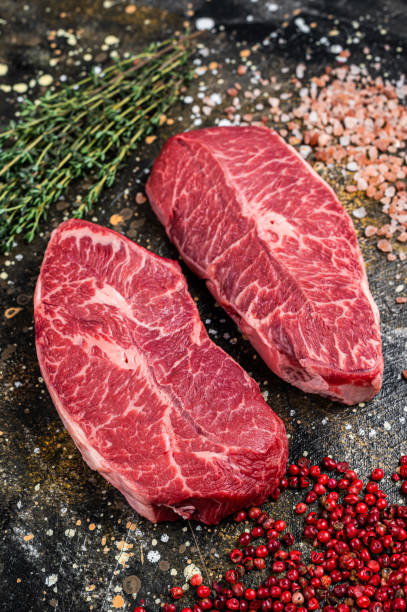 istock Raw Shoulder Top Blade cuts, beef meat steaks. Brown background. Top View 1313012826