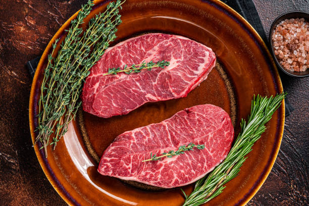 Raw Shoulder Top Blade cut, or Australia wagyu oyster blade beef steak. Dark background. Top View Raw Shoulder Top Blade cut, or Australia wagyu oyster blade beef steak. Dark background. Top View boneless chuck steak stock pictures, royalty-free photos & images