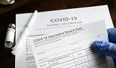 COVID-19 Vaccination Record Card in doctor hand