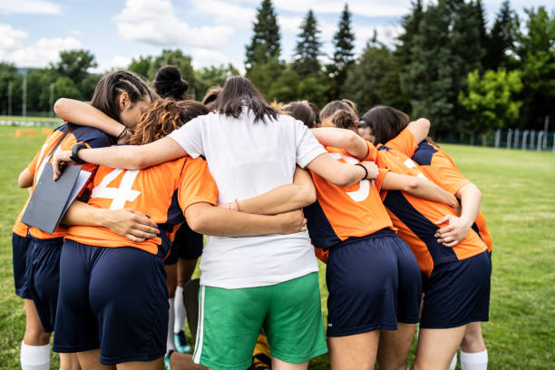istock Women soccer team and coach hugging 1313030498