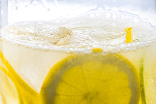 Bubbles on top of lemon drink in glass. Homemade lemonade, source of vitamins, healthy lifestyle concept.
