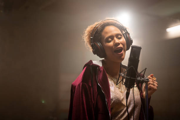 istock Young adult mixed-race woman singing on microphone. Full concentration on performance. 1313030708