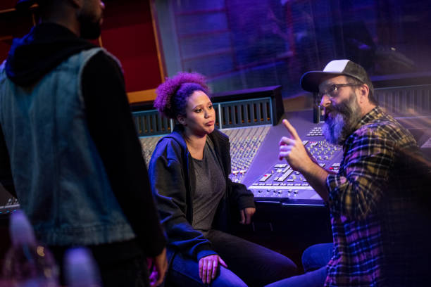 istock Musicians discussing their ideas with sound engineer in recording studio. 1313030716