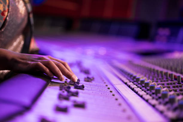 istock Female fingers fine tuning sound by moving faders on mixing control panel. 1313030736