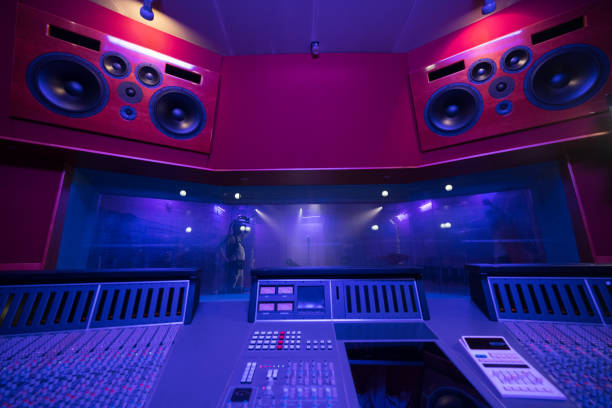 istock Mixing audio control panel, high power speakers and view through soundproof window on musicians. 1313030741