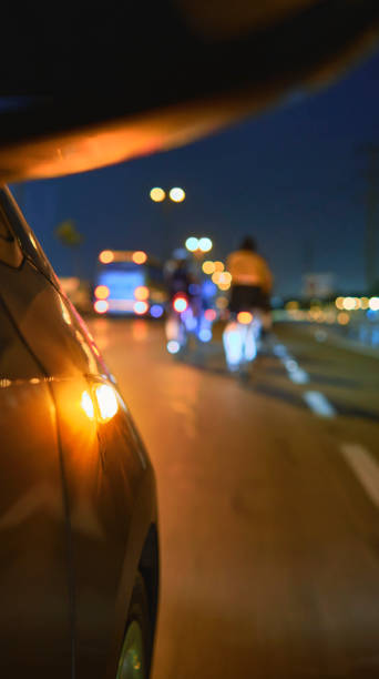 Group of professional cyclists training on highway with safety escort car. A group of cyclists followed by team cars