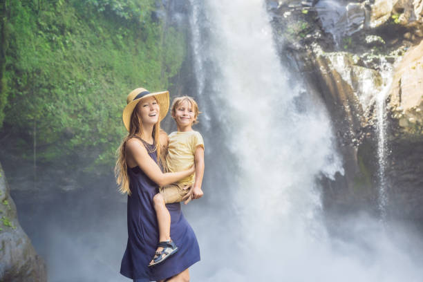 mom and son tourists on the background of a waterfall. traveling with kids concept. what to do with children children friendly place - 2779 imagens e fotografias de stock