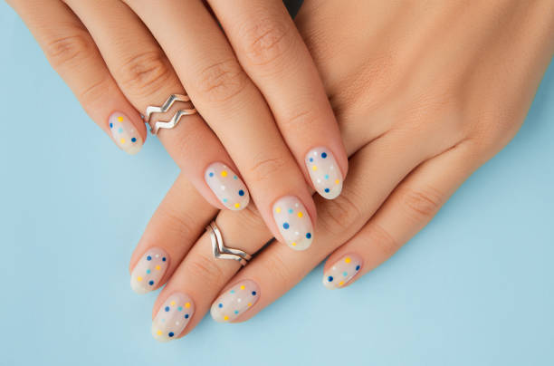 frauen hände mit trendigen polka dot sommer maniküre - fingernagel stock-fotos und bilder