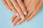 Womans hands with trendy polka dot summer manicure