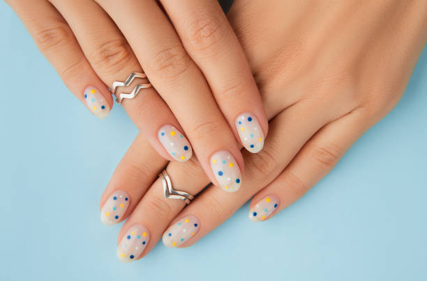 Womans hands with trendy polka dot summer manicure Womans hands with trendy polka dot summer manicure. Beauty treatment spa body care concept fingernail photos stock pictures, royalty-free photos & images