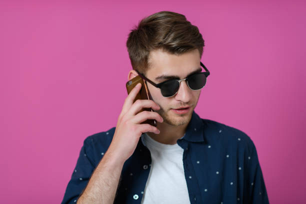 a portrait of a young man wearing a blue shirt and sunglasses using a smartphone with different facial expressions
