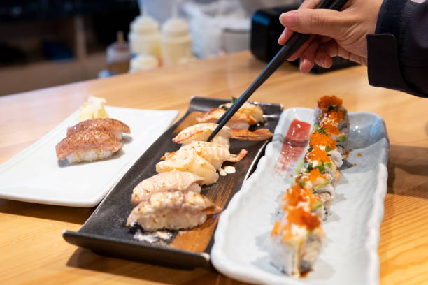 istock A hand picking up Japanese sushi with chopsticks 1313053338