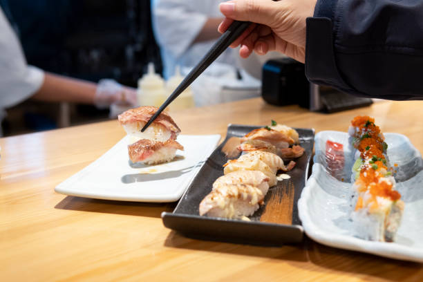 istock A hand picking up Japanese sushi with chopsticks 1313053527