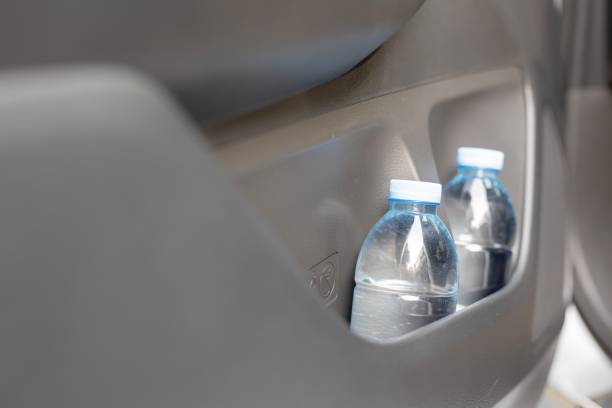 Drinking water in the car prepared for traveling stock photo