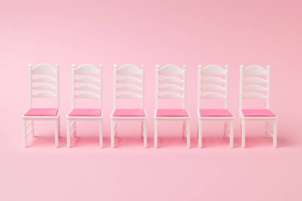 istock A row of six chairs on a pink background. 1313058635
