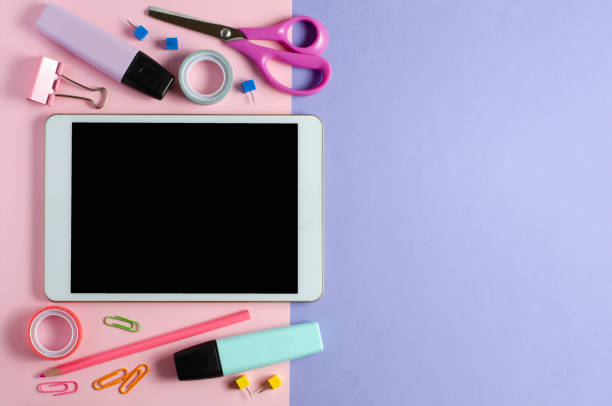 istock A tablet with an empty screen and office supplies on a colored background. Concept app for school children or online learning for children. Copy space 1313058766