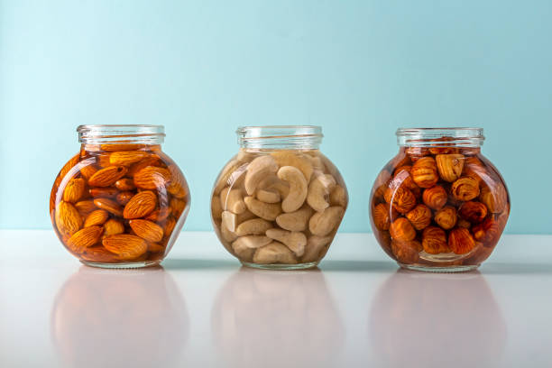 Process of soaking various nuts: almonds, hazelnuts, cashew in water in glass jar to activate. Home Cooking: making plant based organic veggie Milk, lactose free. Process of soaking various nuts: almonds, hazelnuts, cashew in water in glass jar to activate. Home Cooking: making plant based organic veggie Milk, lactose free drenched stock pictures, royalty-free photos & images