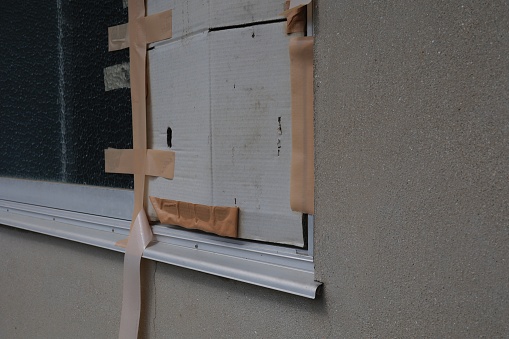 Broken windowpanes are being repaired with cardboard and gum tape.