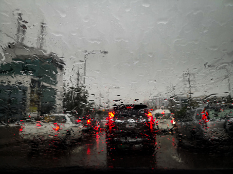 Rain drops on car window glass with blurred background.