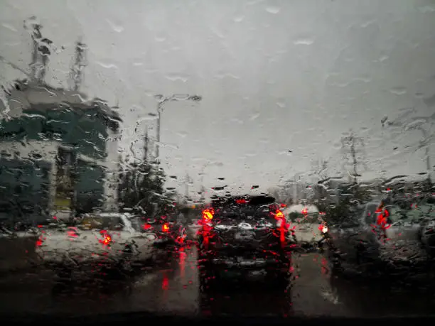 Photo of Rain drops on car window glass with blurred background.