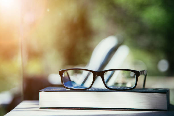 istock Studying outdoors: Glasses on book outdoors in the park, spring time 1313067810