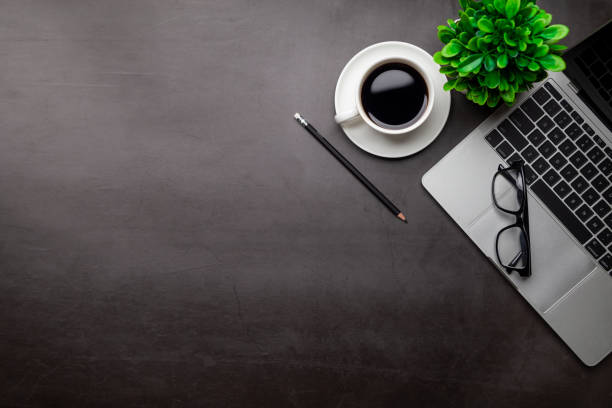 istock Top view desk,Modern office desk Workspace with laptop computer, coffee cup, glasses,notebook and office supplies for Working background concept. 1313069892