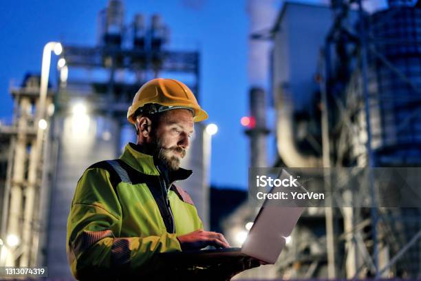 Male Engineer Using Laptop During Night Shift Stock Photo - Download Image Now - Industry, Manufacturing, Power Station