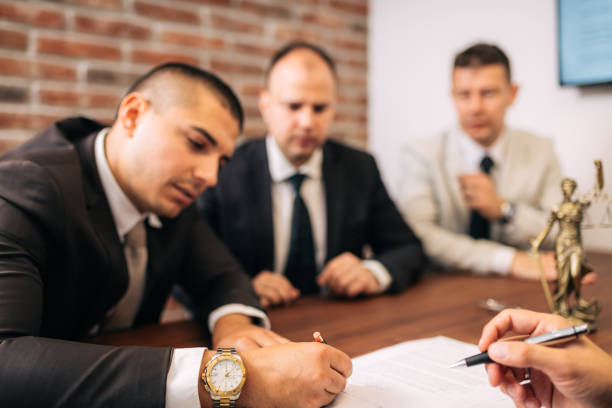 Business people negotiating a contract Close up of lawyer signing formal paper on the office table witness signature stock pictures, royalty-free photos & images