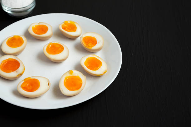 istock Homemade Unami Soy Sauce Eggs on a white plate on a black background, side view. Copy space. 1313077333