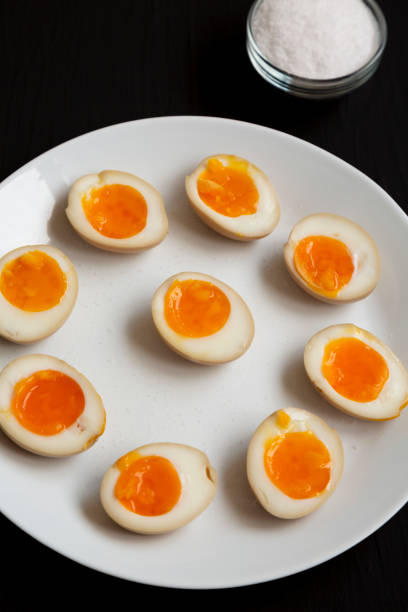 istock Homemade Unami Soy Sauce Eggs on a white plate on a black surface, side view. 1313077353