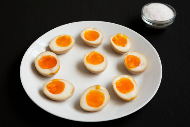 istock Homemade Unami Soy Sauce Eggs on a white plate on a black background, side view. 1313077368