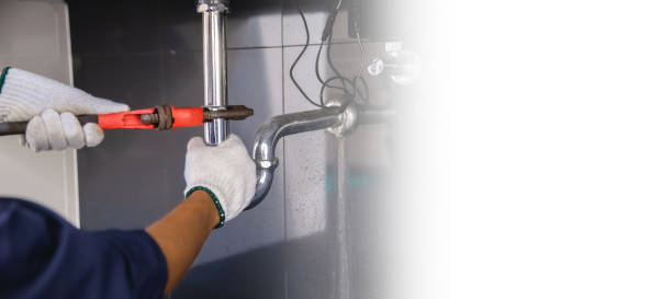 istock Plumber fixing white sink pipe with adjustable wrench. 1313078538