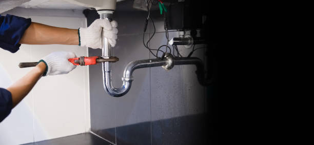 istock Plumber fixing white sink pipe with adjustable wrench. 1313078545