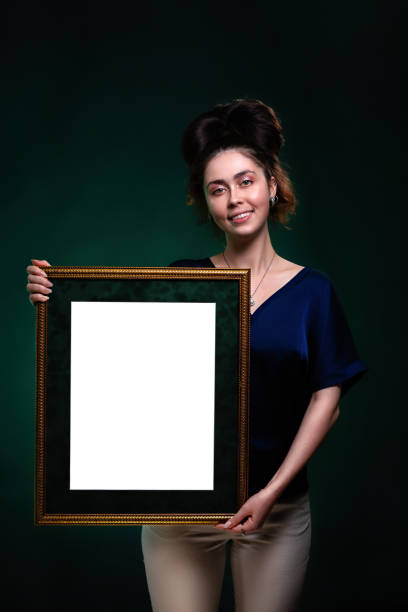 istock A young smiling caucasian woman holds a frame with a white space. Mock up. Copy space 1313082808