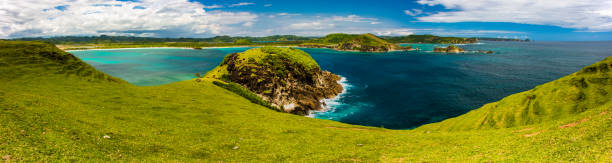 panoramiczny widok na lazurową zatokę z .rocky coast i zielonym nachyleniem pastwisk, indonezja - nowt zdjęcia i obrazy z banku zdjęć