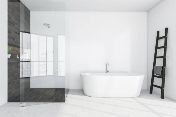 istock Light bathroom with bathtub and glass shower 1313083445