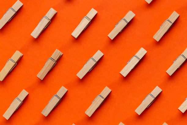 istock Many wooden clothespin on orange background. 1313085463