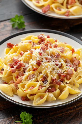 Classic Pasta carbonara with bacon, egg, cream, black pepper and Parmesan Cheese on plate. Italian food.