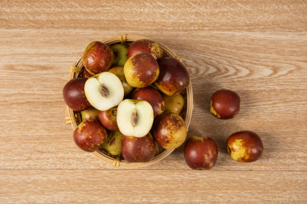 fresh sliced chinese jujubes on wood background fresh sliced chinese jujubes on wood background jujube fruit stock pictures, royalty-free photos & images