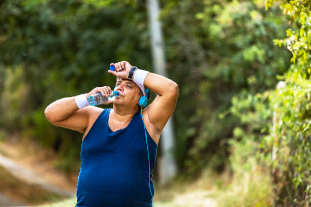 istock Fitness man drinking water from bottle. Thirsty athlete having cold refreshment drink after intense exercise. 1313089970