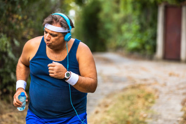istock Overweight man slowly running outdoors, active lifestyle as struggle with obesity 1313089998