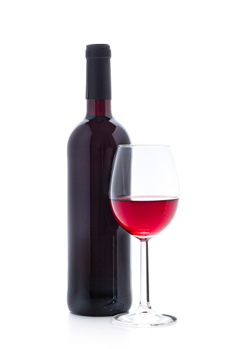 Front view of a glass full of red wine with a wine bottle isolated on white background. Studio shot taken with Canon EOS 6D Mark II and Canon EF 100 mm f/ 2.8